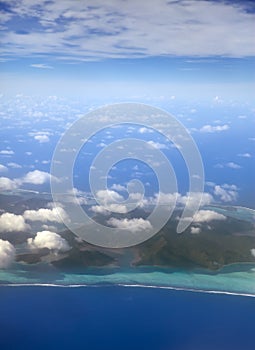 Polynesia. The atoll in ocean through clouds. Aerial view