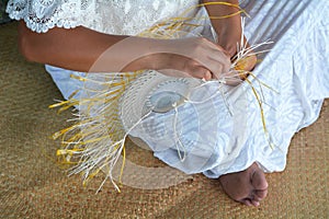 Polynesian Cook Islander woman weaving a hand fan in Rarotonga C