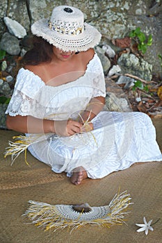 Polynesian Cook Islander woman weaving a hand fan in Rarotonga C