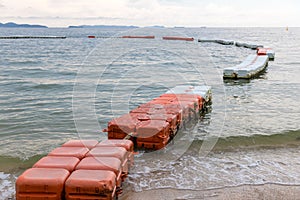 Polystyrene buoy on the sea surface. floating buoys and rope dividing area on the beach.