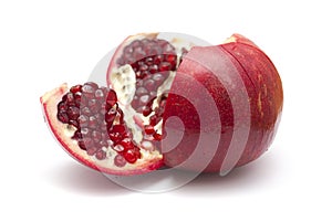 Pomegranate being broken into segments isolated on white