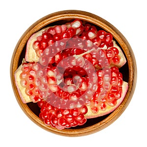 Pomegranate clusters, Punica granatum, in a wooden bowl