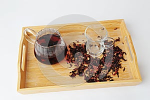 Pomegranate flowers tea is brewed in glass teapot. Bamboo tray. Beautiful ruby infusion. Flower drink, healthy food