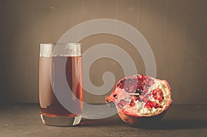 Pomegranate fruit and juice in glass/ Pomegranate fruit and juice in glass on dark background