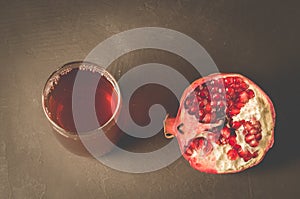 Pomegranate fruit and juice in glass/Pomegranate fruit and juice in glass on dark background, top view