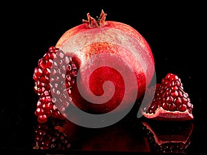 Pomegranate fruit. Pomegranates over black Background. Organic Bio fruits photo