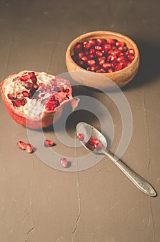 pomegranate fruit, the purified pomegranate seeds in a wooden bowl/Pomegranate fruit and grains in a wooden bowl and a spoon