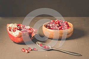 pomegranate fruit, the purified pomegranate seeds in a wooden bowl/Pomegranate fruit and grains in a wooden bowl and a spoon