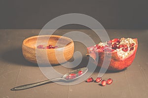 pomegranate fruit, the purified pomegranate seeds in a wooden bowl/Pomegranate fruit and grains in a wooden bowl and a spoon