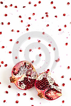 Pomegranate fruit and seeds on white background