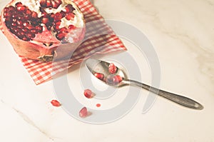 pomegranate fruit and seeds on a white background and in a spoon/pomegranate fruit and seeds on a white background and in a spoon