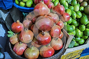 Pomegranate fruits and lemons in baskets at the street bazaar