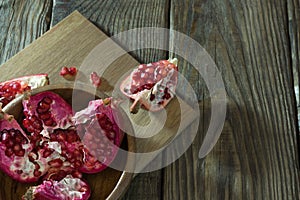 Pomegranate grains in a wooden bowl closeup