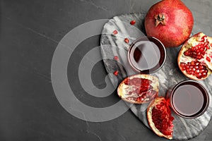 Pomegranate juice and fresh fruits on dark table, top view. Space for text
