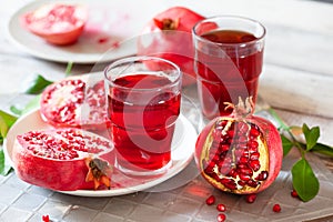 Pomegranate juice with fresh pomegranate fruits on wooden table