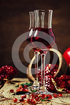 Pomegranate liqueur, still life in rustic style, vintage wooden