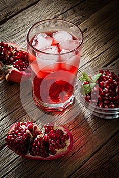 Pomegranate with and pomegranate juice on wooden background