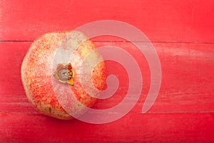 Pomegranate on a red wooden background