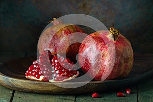 pomegranate seeds fruit Fresh ripe wooden background open dark vintage background still life organic Red vitamins wooden plate