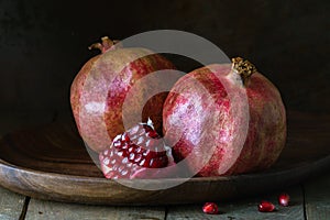 pomegranate seeds fruit Fresh ripe wooden background open dark vintage background still life organic Red vitamins wooden plate