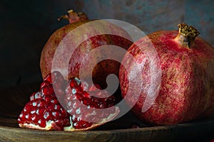 pomegranate seeds fruit Fresh ripe wooden background open dark vintage background still life organic Red vitamins wooden plate