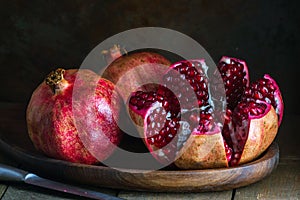 pomegranate seeds fruit Fresh ripe wooden background open dark vintage background still life organic Red vitamins wooden plate