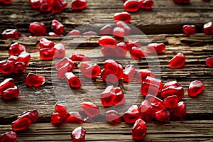 Pomegranate seeds over wooden table. Selective focus