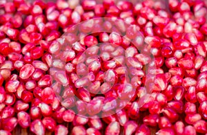 Pomegranate seeds, red, lie on a wooden