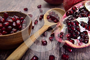 Pomegranate seeds on a wooden bowl