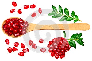 Pomegranate seeds in wooden spoon isolated on white background. top view. pomegranate berries