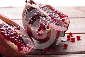 Pomegranate slices and garnet fruit seeds on table