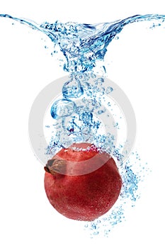 Pomegranate splashing in water