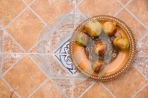 Pomegranates on pattered wooden plate. Tiles