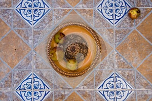 Pomegranates on pattered wooden plate. Tiles