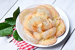 Pomelo fruit on white plate with leaf , fresh pomelo peeled frome pomelo tree , pummelo , Cloce up grapefruit in summer tropical