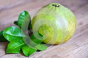 Pomelo fruit on wooden background, fresh green pomelo and green leaf frome pomelo tree , pummelo , grapefruit in summer tropical