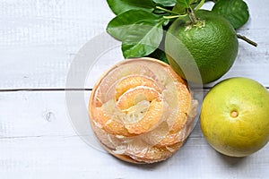 Pomelo fruit on wooden plate  background, fresh green pomelo peeled and leaf frome pomelo tree , pummelo , grapefruit in summer