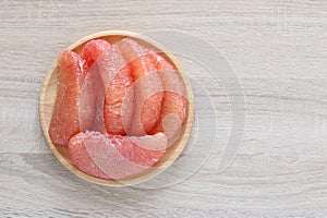 Pompelmoes,Fresh red pomelo fruit in a bowl on wooden background, (Tubtim Siam Pomelo