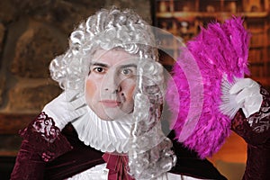 Pompous baroqure man with pink feather hand fan