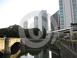 Pond with bridge near public garden in the central part of Tokyo city