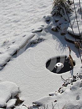 Pond with an electric heater melting the ice in winter