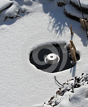 Pond with an electric heater melting the ice in winter