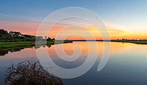 Pond in front of Edgartown lighthouse full of sunrise colors