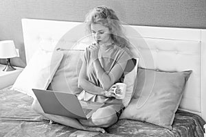 pondering woman freelancer with coffee work at home on laptop. freelancer woman work at home.