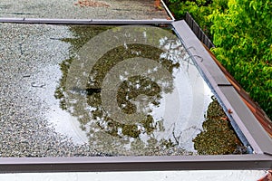 Ponding standing water on a flat roof after heavy rain