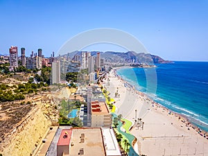 Poniente beach of Benidorm in summer seen from the heights of a skyscraper with the beach, the sea and other buildings of hotels photo