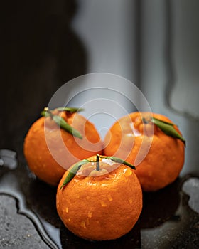 Ponkan tangerines on a dark, wet table. Ponkan ripe and wet. Poncan. Selective focus photo