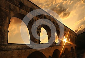 Pont du Gard ancient Roman aqueduct bridge at sunset rays