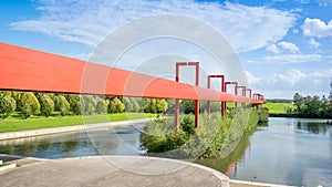 Pont Rouge in Cergy, France against a cloudy blue sky photo