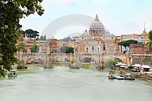 Ponte Sant` Angelo with St. Peter`s Basilica in background across Tiber River, Rome, Italy